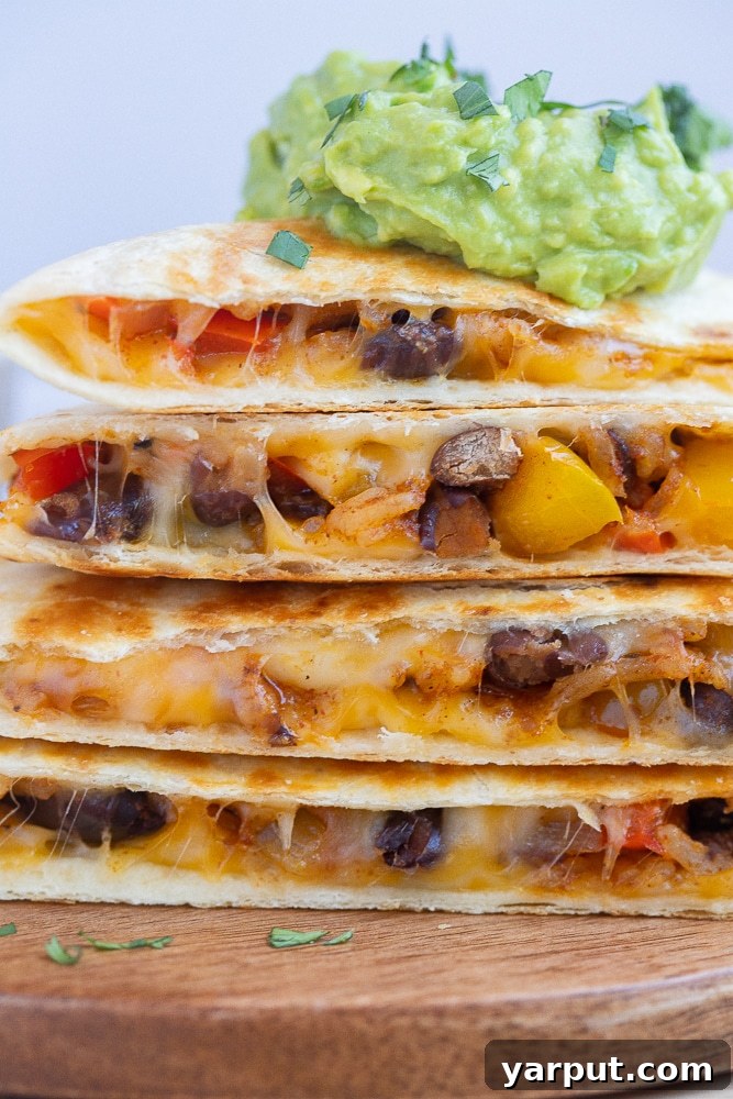 Sizzling Fajita Rice & Bean Quesadillas 7 close up of vegetarian fajita quesadillas stacked on top of each other
