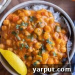 A vibrant bowl of Pumpkin Red Curry Chickpeas with Vegetables, served with rice.