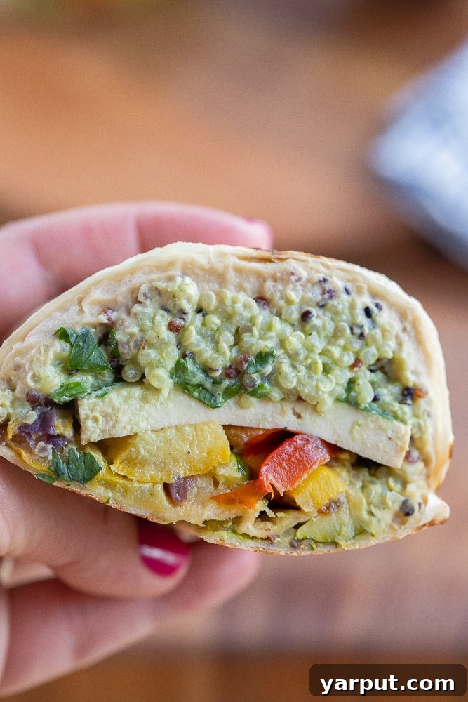Protein-Packed Veggie Wraps 2 hand holding a cross section view of a high protein vegetarian wrap
