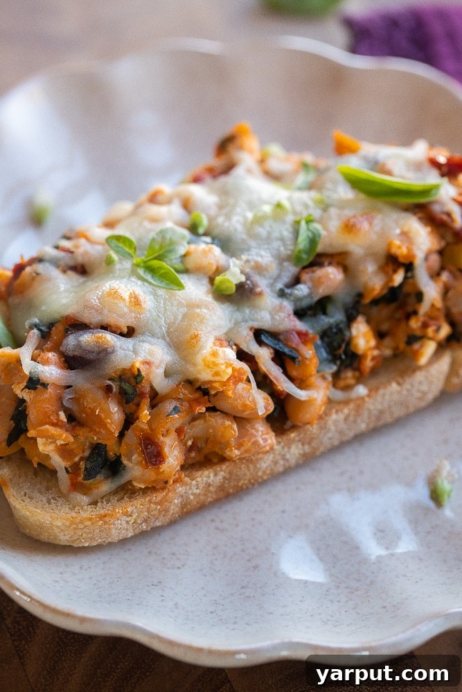 Tuscan White Bean Toast 7 Close up of Tuscan white beans on toast with melted cheese