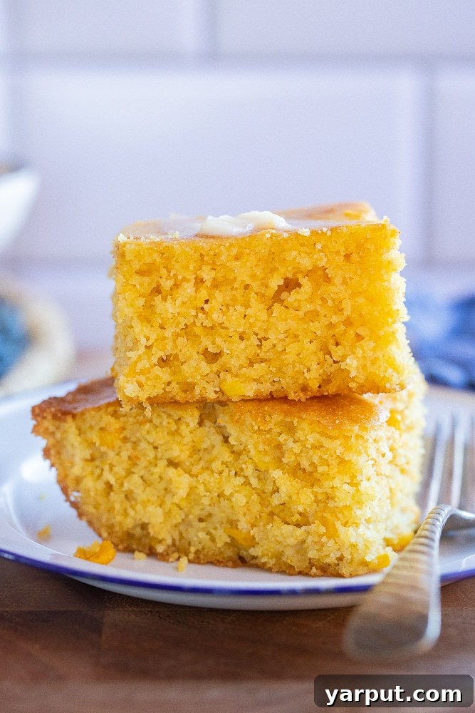 Golden Cornbread Perfection 2 A close-up of a golden-brown slice of cornbread, showing its moist texture and topped with melting butter, inviting a warm and comforting experience.