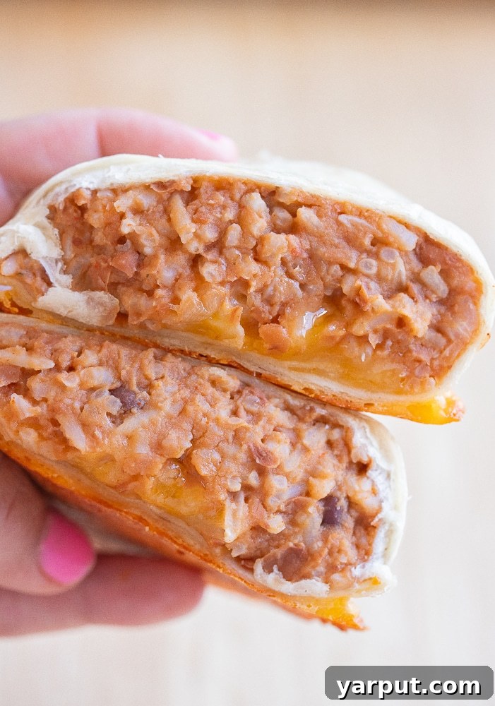 Effortless Plant-Based Meals Week 11 3 Cheesy Bean and Rice Burritos on a plate with salsa and chips
