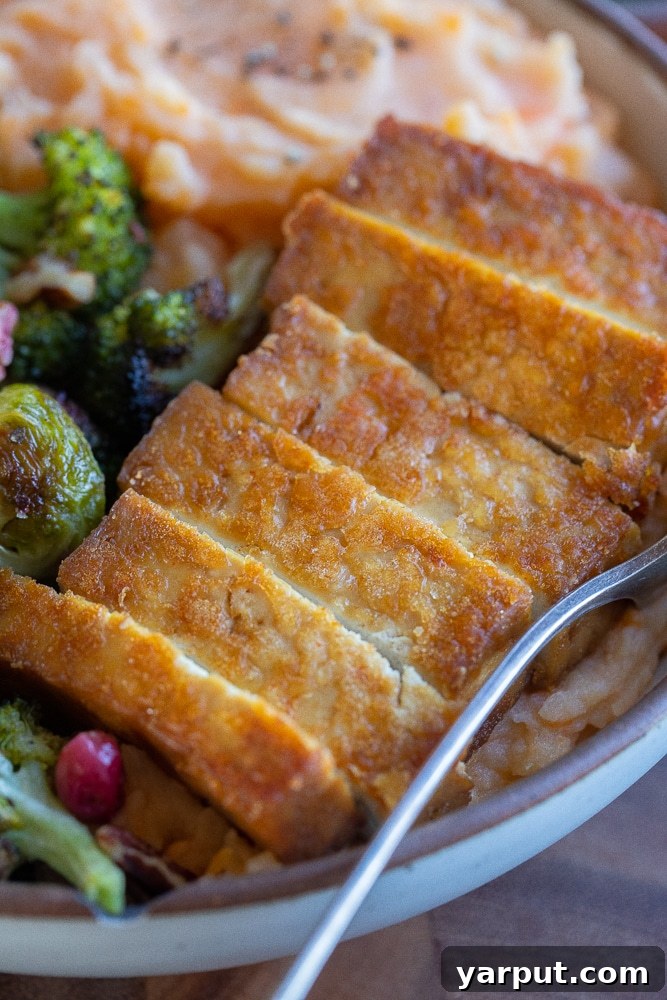 Harvest Veggie Thanksgiving Bowls 8 Close-up of golden brown sliced tofu, showing its crispy exterior and succulent interior, ready to be added to the Thanksgiving bowl.