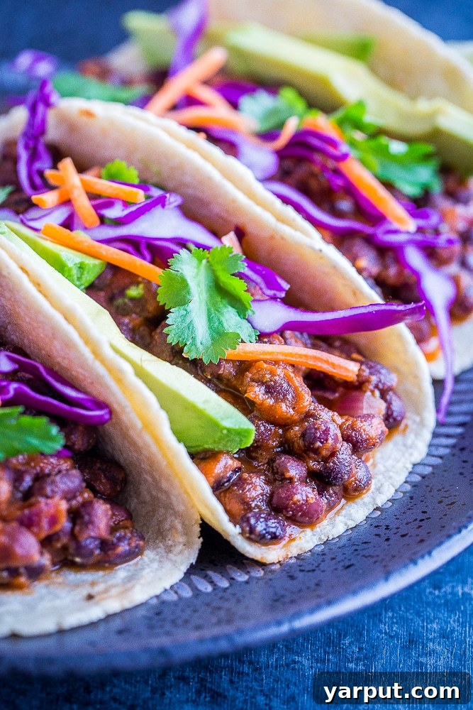 A World of Lentil Chickpea and Bean Delights 9 Colorful black bean tacos overflowing with fresh summer vegetables and vibrant toppings.