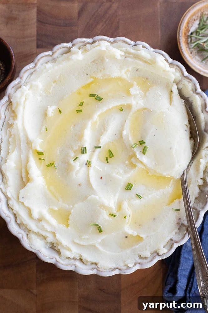 Velvety Smooth Mashed Potatoes 7 A top-down view of a bowl of mashed potatoes, garnished with a sprinkle of fresh herbs.