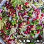 Merry & Bright Coleslaw 9 Close-up of vibrant Christmas Coleslaw Salad in a serving bowl, showcasing fresh vegetables and pomegranate seeds.