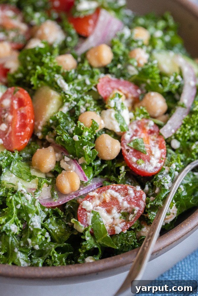 40+ Festive Vegetarian Side Dishes 17 A colorful lemony kale salad with feta cheese, cherry tomatoes, and chickpeas in a large serving bowl.