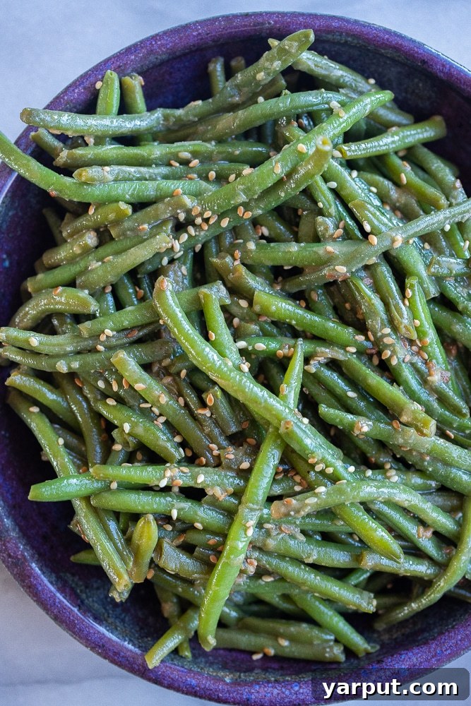 40+ Festive Vegetarian Side Dishes 23 Vibrant green beans tossed with miso and sesame seeds, presented in a bowl.