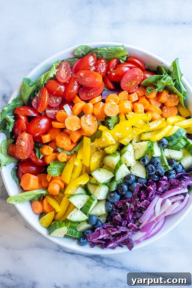 40+ Festive Vegetarian Side Dishes 27 A vibrant rainbow veggie salad, featuring a colorful assortment of fresh fruits and vegetables.