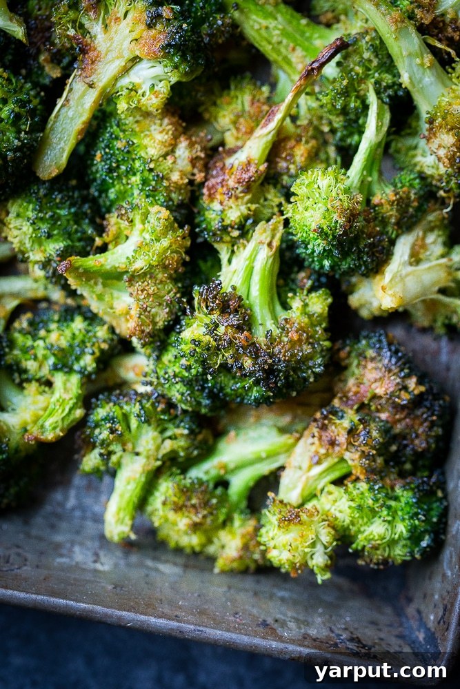40+ Festive Vegetarian Side Dishes 41 Close-up of cheesy roasted broccoli with garlic, showing melted cheese and tender florets.