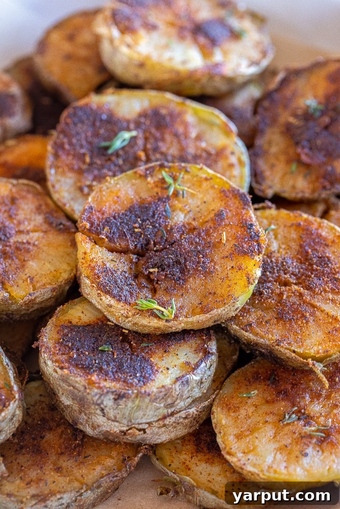 40+ Festive Vegetarian Side Dishes 7 Roasted blackened potatoes, with a dark, flavorful crust and soft interior, garnished with fresh herbs.