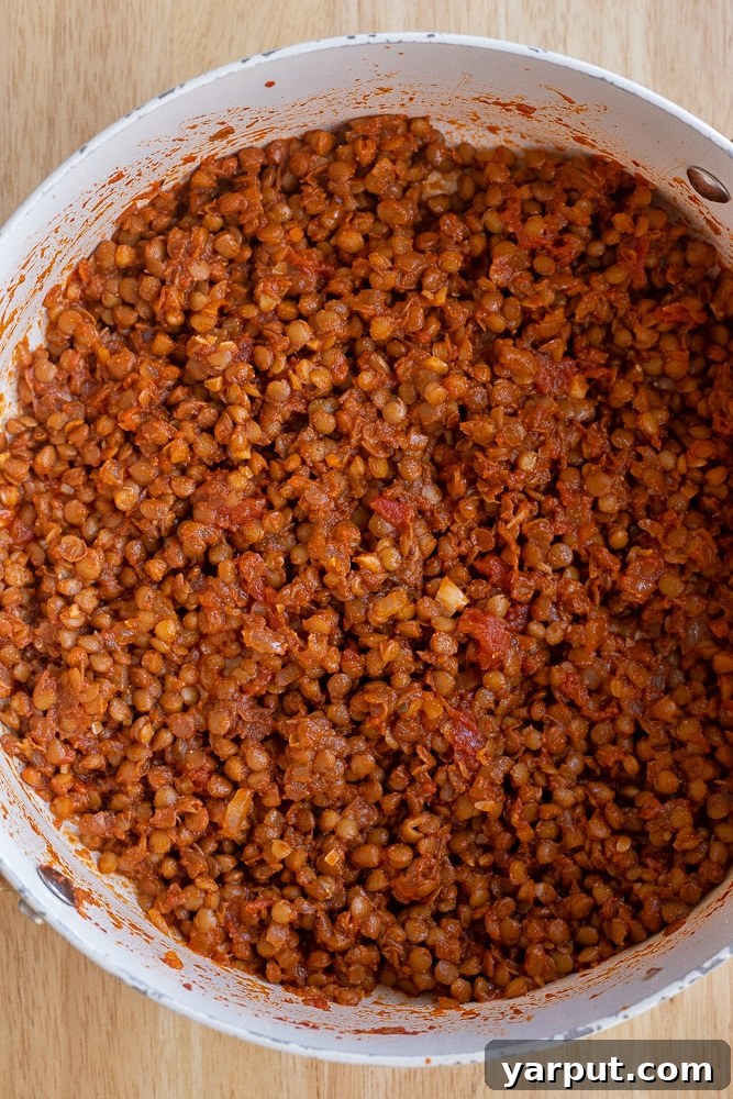 Golden Cheesy Baked Lentil Tacos 4 A close-up view of seasoned lentils simmering in a pot, showcasing their rich, flavorful sauce
