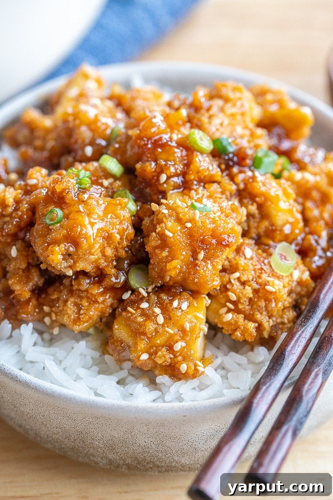 Plant-Powered 2026: Week 2 Meal Plan 7 Crispy Honey Garlic Tofu garnished with sesame seeds and green onions, ready to be enjoyed.