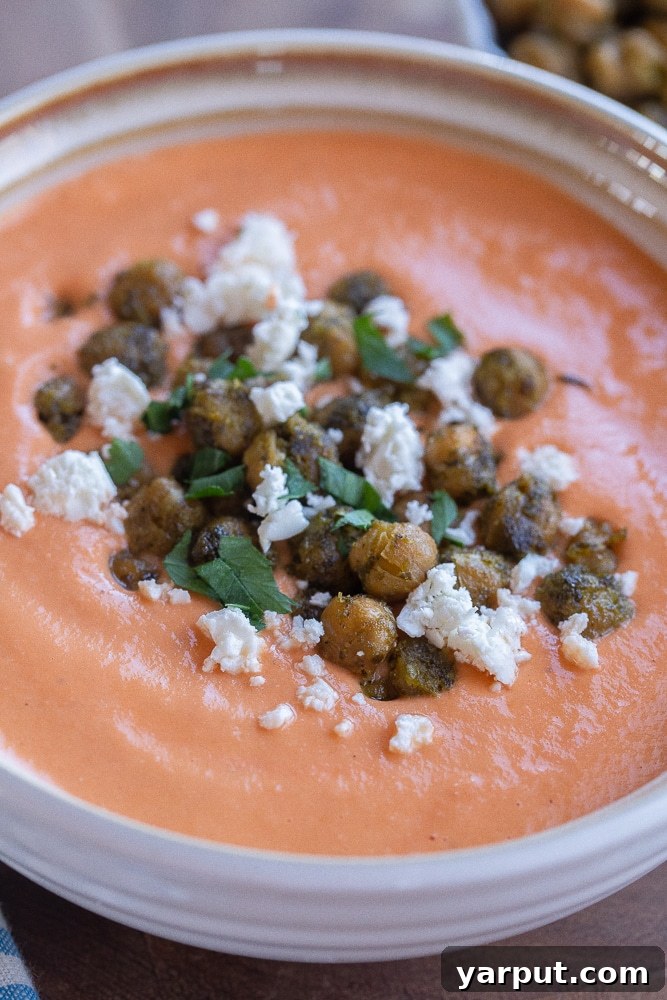 A very close-up, inviting shot of a bowl of comforting tomato feta soup, highlighting its rich, creamy texture and warm tones, perfect for a chilly day.
