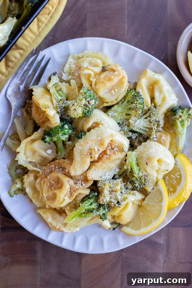 Zesty Roasted Lemon Parmesan Tortellini with Broccoli 6 A beautifully arranged dinner plate showcasing a generous serving of roasted tortellini with broccoli, ready to be enjoyed, garnished with fresh Parmesan.
