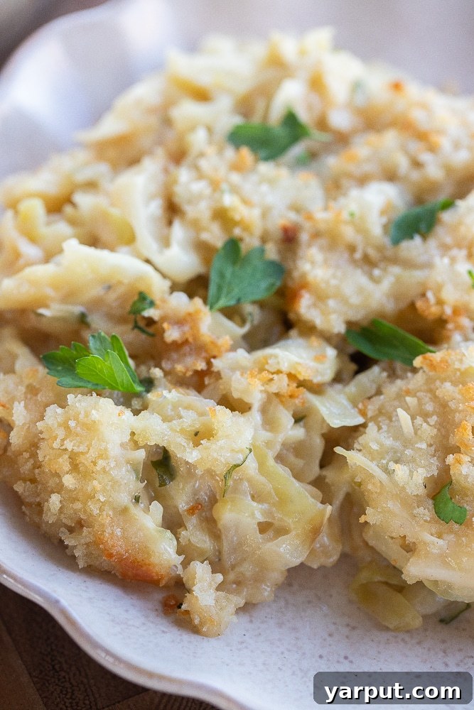Golden Cheesy Cabbage Bake 8 A close-up of cheesy baked cabbage, showing the crispy, golden-brown breadcrumb topping and bubbling cheese beneath.
