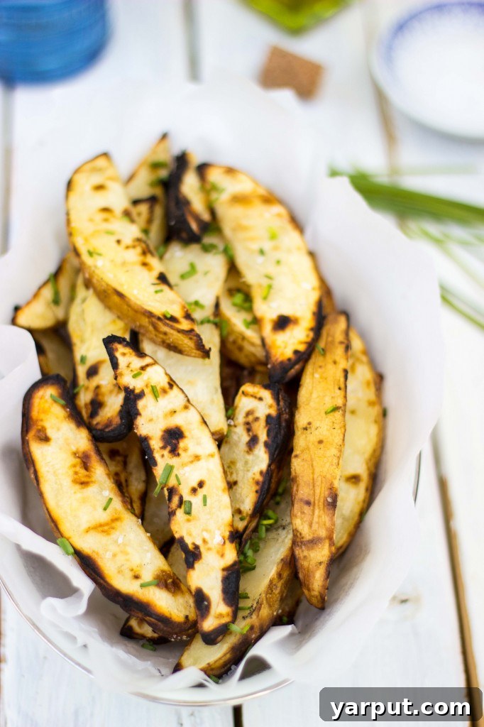Zesty Salt and Vinegar Char-Grilled Potato Wedges 14 A vibrant platter of Salt & Vinegar Grilled Potato Wedges with a blurred background.