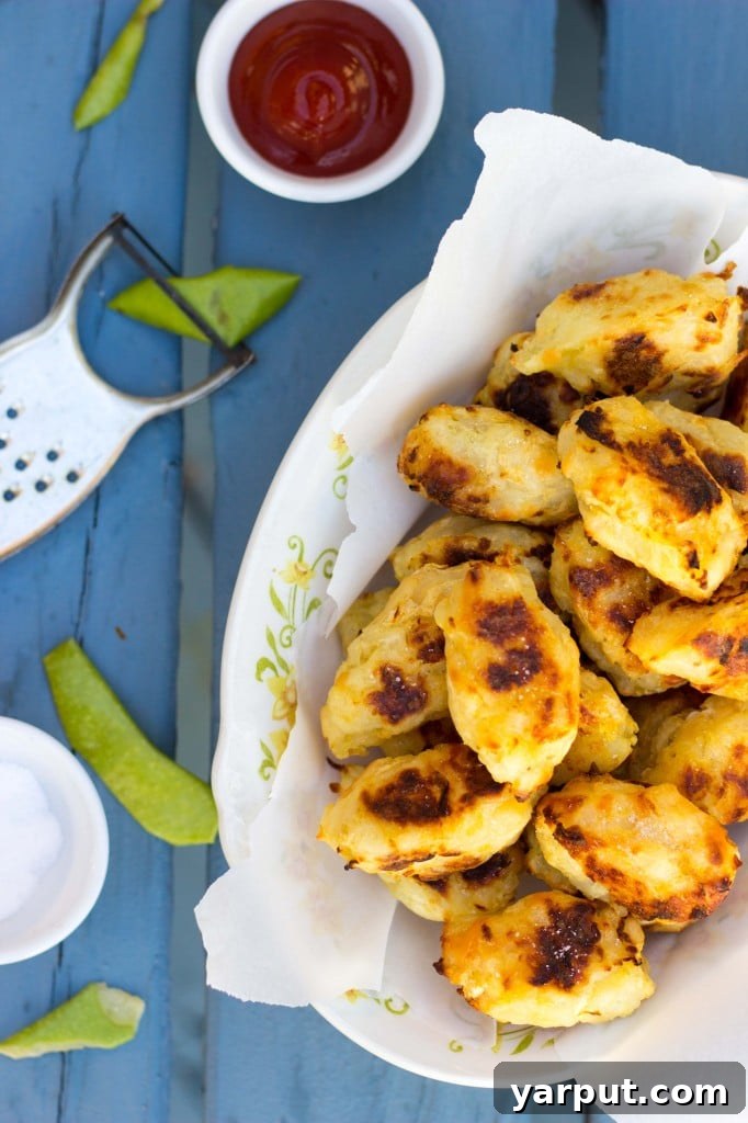 Closeup of baked tater tots with smoked gouda and green apple, showing texture