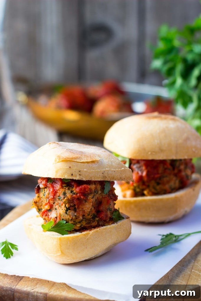 Plant-Powered Feta and Kale Sliders with White Beans 2 Vegetarian Meatball Sliders with Kale, White Beans & Feta - A close-up shot of the sliders on a wooden board