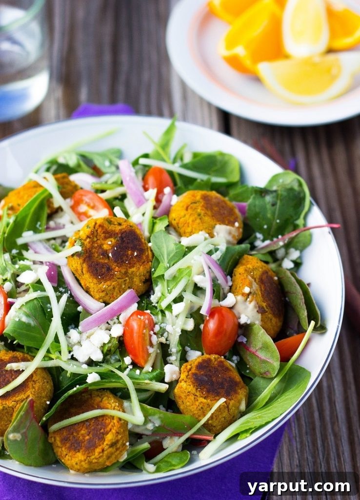 A side view of the freshly prepared Roasted Carrot Falafel Salad, showcasing the height and volume of the ingredients, and the inviting textures.