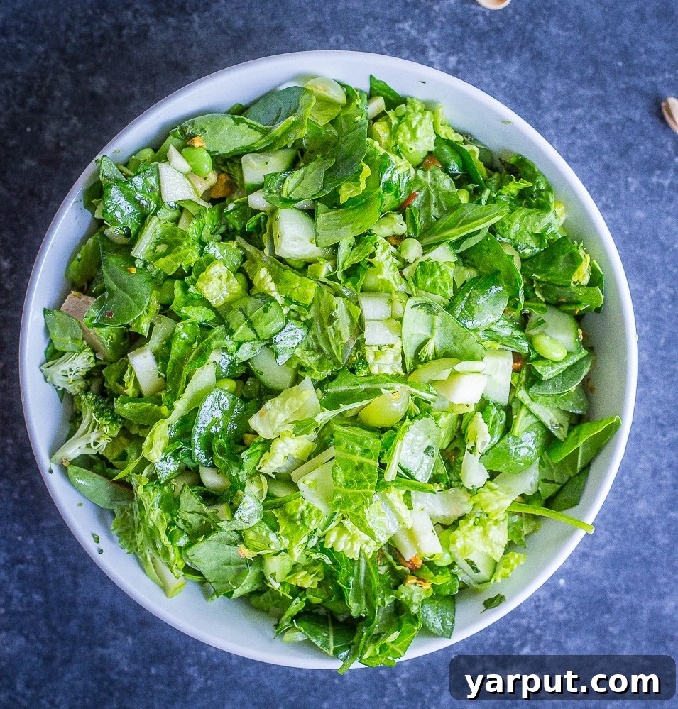 Ultimate Green Chopped Medley 4 A bowl of the vibrant green dressing for The Greenest Chopped Salad, made with olive oil, lemon juice, Dijon mustard, maple syrup, fresh herbs, and garlic.