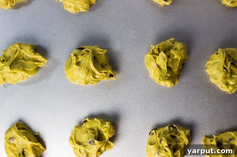 Close-up of a freshly baked Avocado Chocolate Chip Pistachio Cookie, showing its moist interior