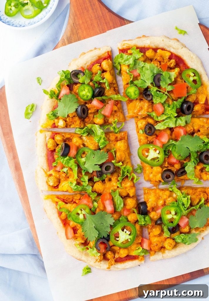 Fiesta Smashed Chickpea Pizza 5 A vibrant close-up of Smashed Chickpea Taco Pizza, showcasing its generous toppings and golden crust.