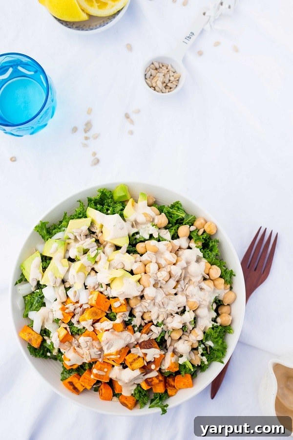 Hearty Kale Salad with Roasted Sweet Potato, Chickpeas, Avocado, and Tahini Miso Dressing 8 Close-up of freshly made Kale Salad, highlighting the dressing and textures