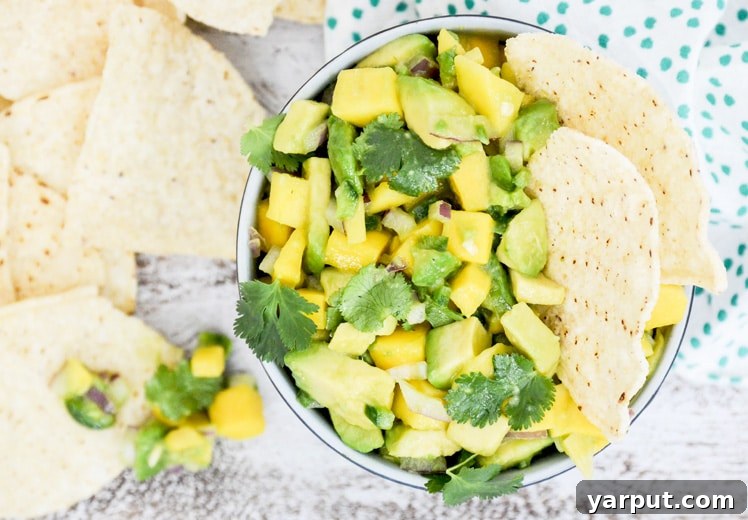 Savor Summer: 13 Vegetarian Avocado Delights 14 Vibrant Tequila Spiked Mango and Avocado Salsa in a bowl