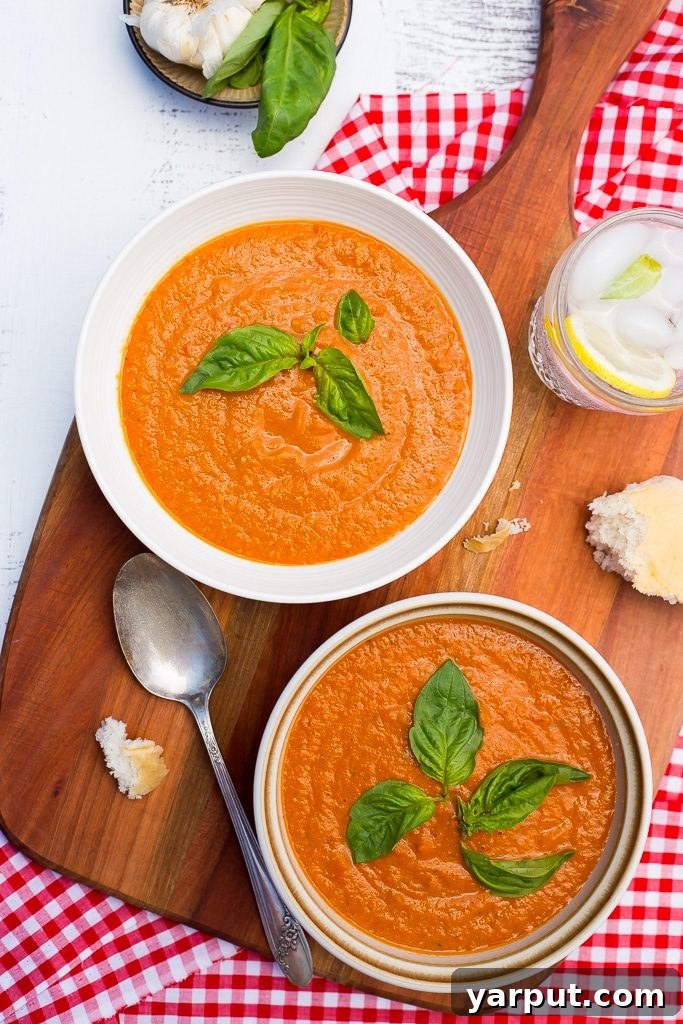 A serving of vibrant chilled cherry tomato soup, garnished with fresh herbs