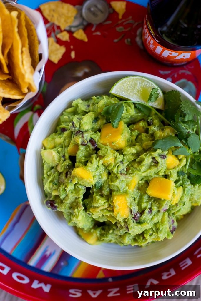 Freshly made Mango Black Bean Guacamole in a bowl, showing diced avocado, mango, and black beans. A perfect healthy dip or appetizer.