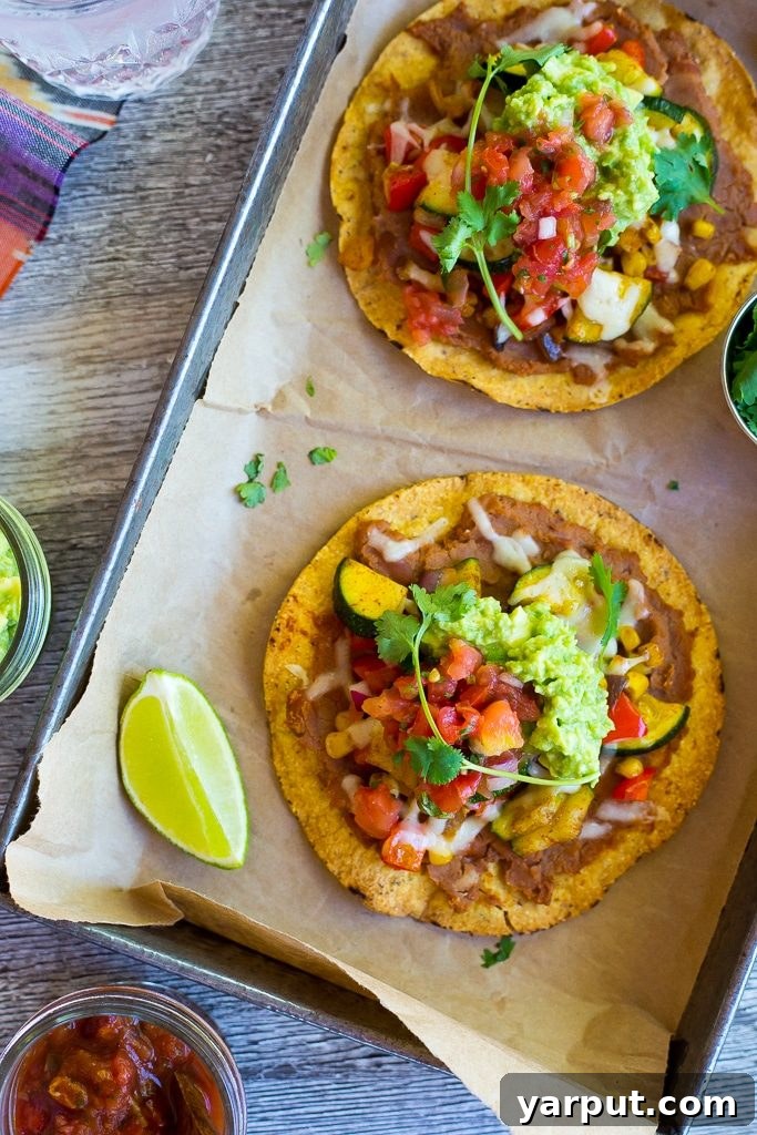 A vibrant close-up of finished Summer Vegetable Tostadas on a white plate.