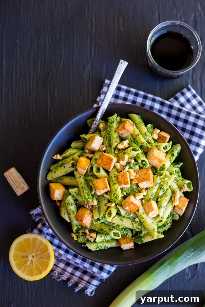 Finished Kale and Leek Pesto Pasta with Tofu garnished with fresh herbs