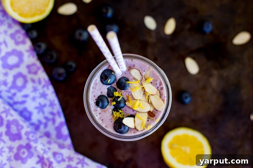 A refreshing and vibrant Lemon, Wild Blueberry & Almond Protein Smoothie, presented in a clear glass, ready to be enjoyed as a healthy and energizing breakfast or snack.