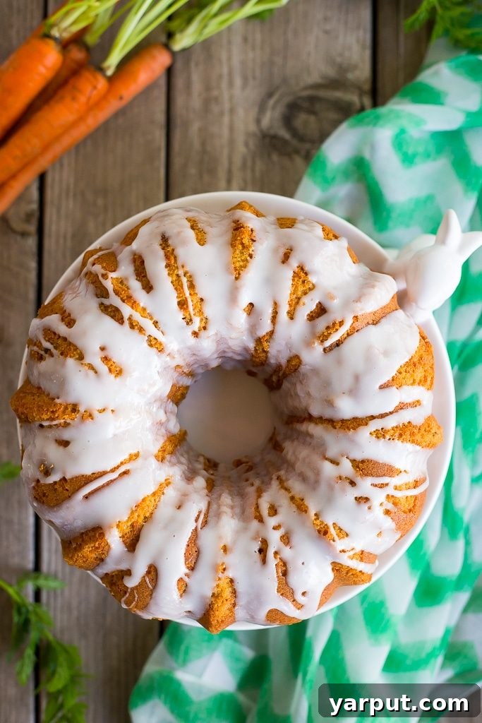 Beautifully iced Gluten-Free Carrot Pound Cake on a rustic wooden board.