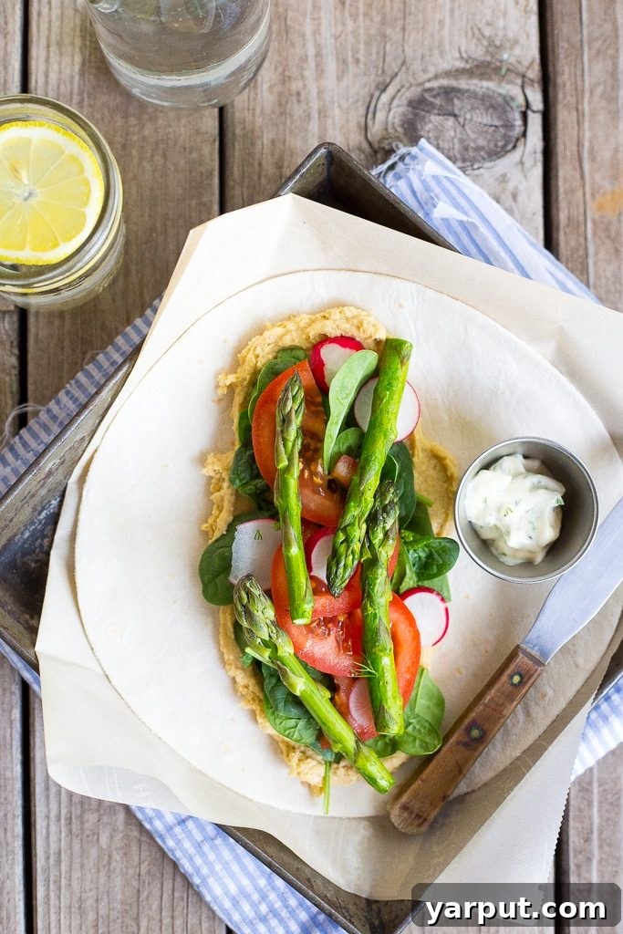 A beautifully arranged Hummus Wrap with fresh spring vegetables, emphasizing its healthy and appealing qualities.