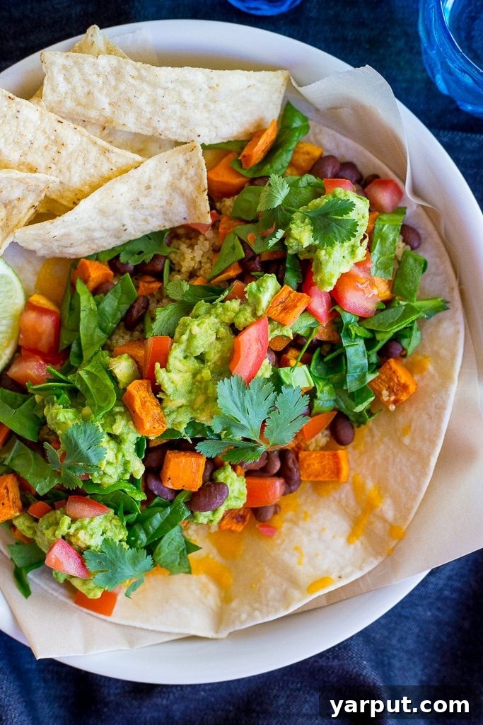 Ultimate Seven Layer Vegetarian Burritos 4 Hand holding a perfectly wrapped 7-Layer Vegetarian Burrito, showing the hearty filling and the soft, flexible Udi's gluten-free tortilla.