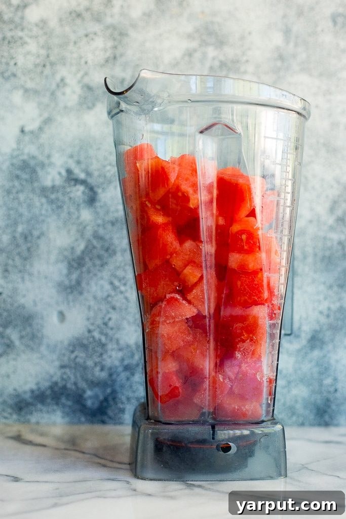 Sadece Karpuzla Buz Gibi Serinlik! 3 Close-up shot of a frosty watermelon slushie in a glass, highlighting its smooth, icy texture and bright pink hue.