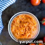 A small bowl of homemade Easy Cherry Tomato Jam with a spoon, ready to serve.