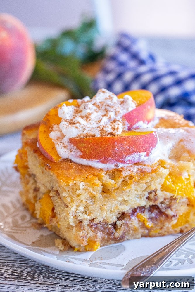 Golden Peach Crumble Cake 6 Close up view of a slice of fresh peach cake with visible streusel filling and juicy peach chunks