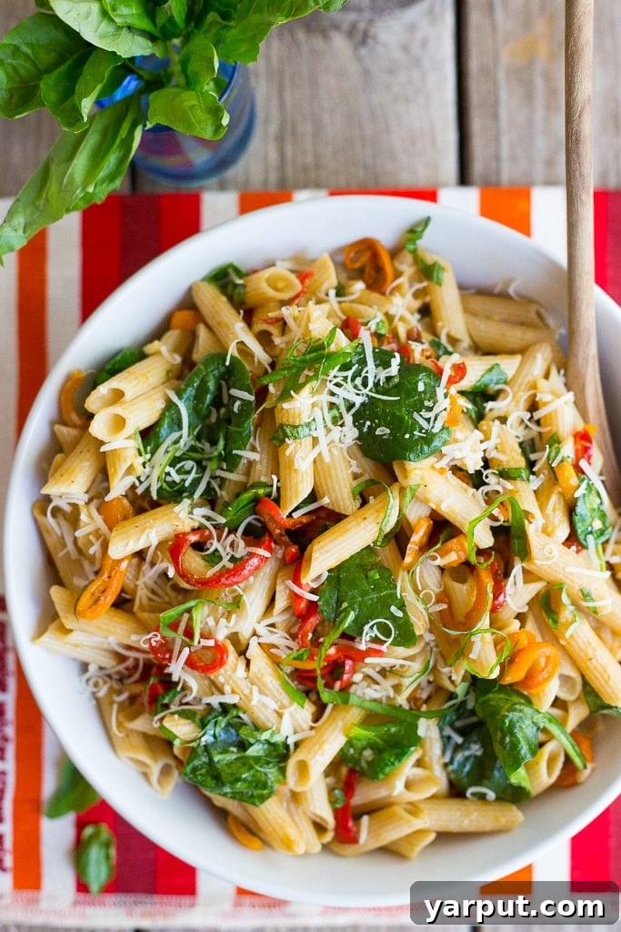 Sweet Pepper Balsamic Pasta with Fresh Spinach and Shaved Parmesan 4 Overhead shot of Balsamic Sweet Pepper Pasta in a large serving bowl with fresh basil garnish