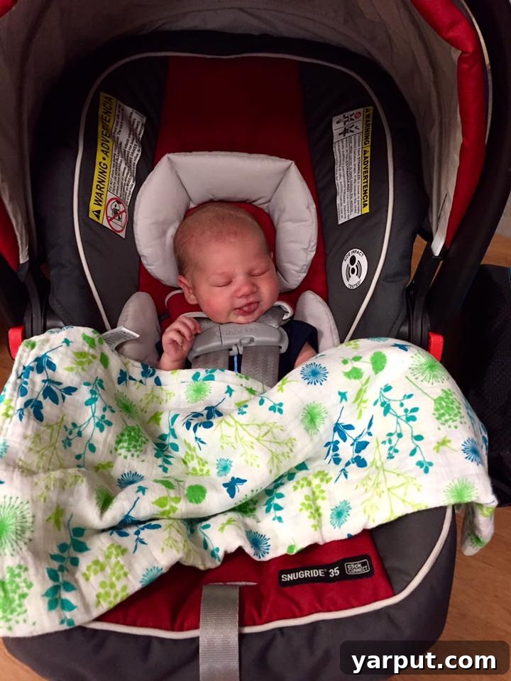 A newborn baby, Elijah, being held, looking healthy and content.