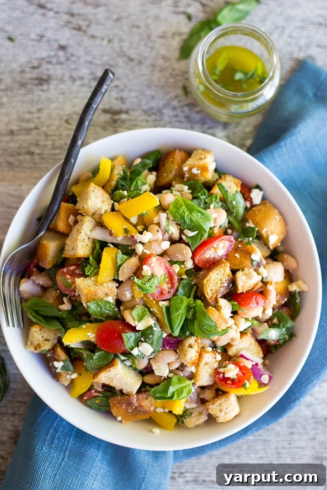 Basil Burst Panzanella with Spinach and White Beans 2 A beautifully plated Spinach and White Bean Panzanella Salad, showcasing toasted bread cubes, vibrant cherry tomatoes, fresh spinach, and white beans, drizzled with basil vinaigrette. Perfect for a hearty, healthy lunch.