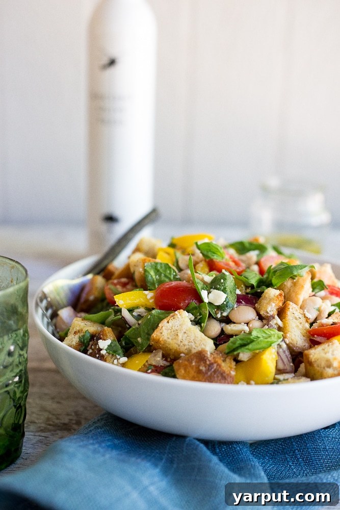 Basil Burst Panzanella with Spinach and White Beans 5 A vibrant close-up of the Spinach and White Bean Panzanella Salad with Basil Vinaigrette, focusing on the texture of toasted bread, and the glossy dressing on fresh vegetables.