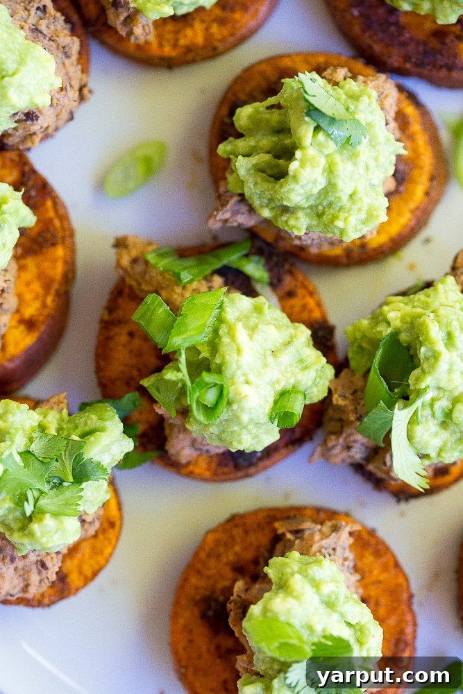 Close-up of healthy Sweet Potato Bites topped with rich Black Bean Hummus and creamy Guacamole, perfect for a vegan and gluten-free diet.