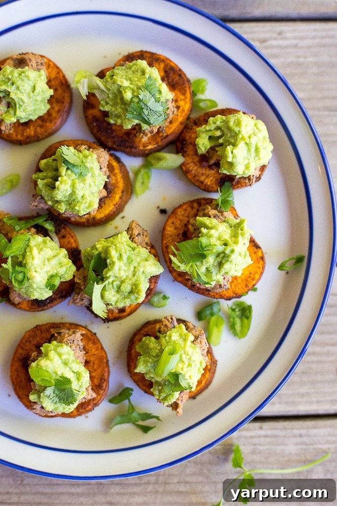 Close-up shot of individual Sweet Potato Bites, showcasing the perfect layering of roasted sweet potato, rich black bean hummus, and bright guacamole.