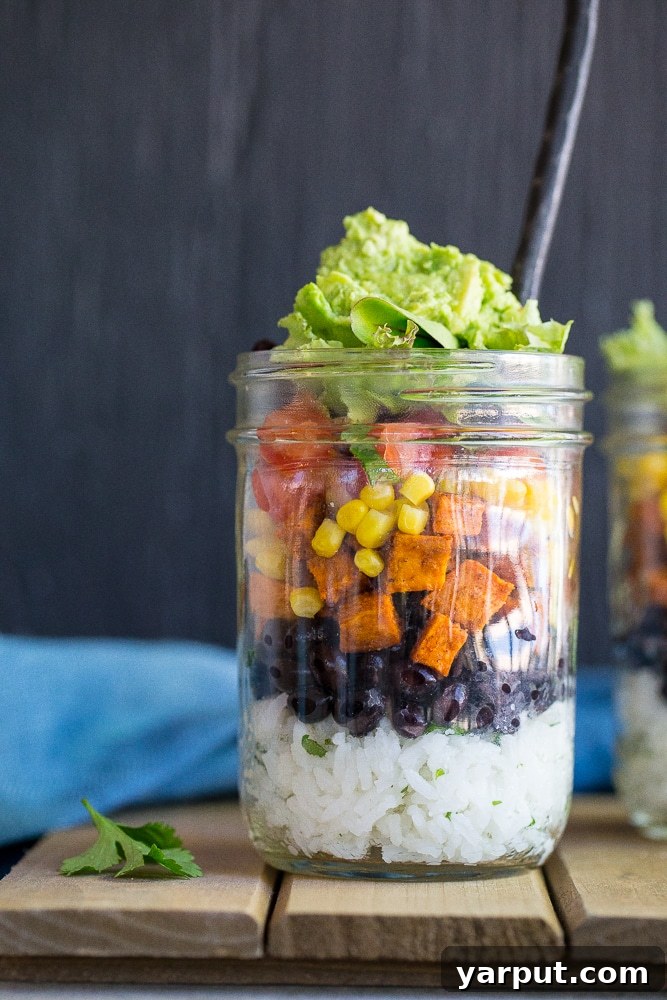 Portable Plant-Based Burrito Bowls 5 A final shot of a beautifully layered Vegetarian Mason Jar Burrito Bowl, showcasing all the ingredients nestled together, emphasizing its appeal as a healthy, vibrant, and ready-to-eat meal.
