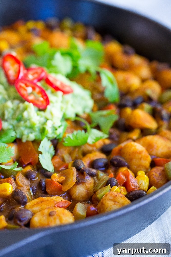 Detailed shot of the Gnocchi Enchilada Skillet bubbling in the pan, showing the vibrant sauce and perfectly cooked ingredients.