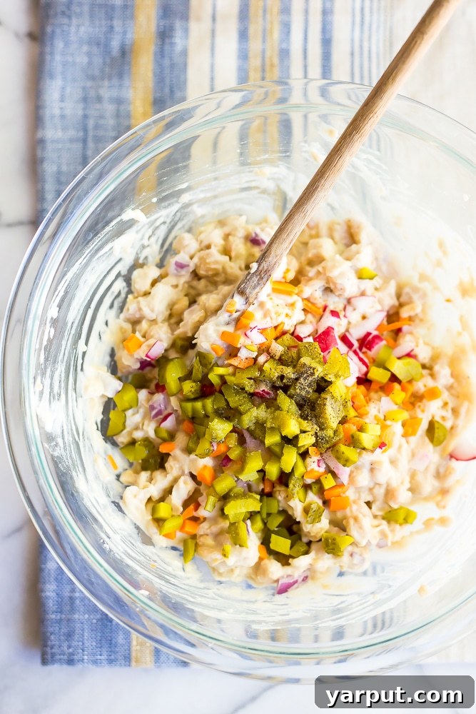 Quick & Hearty Chickpea and White Bean Sandwich Filling 3 Close-up of a prepared chickpea and white bean salad sandwich showing creamy filling and fresh vegetables.