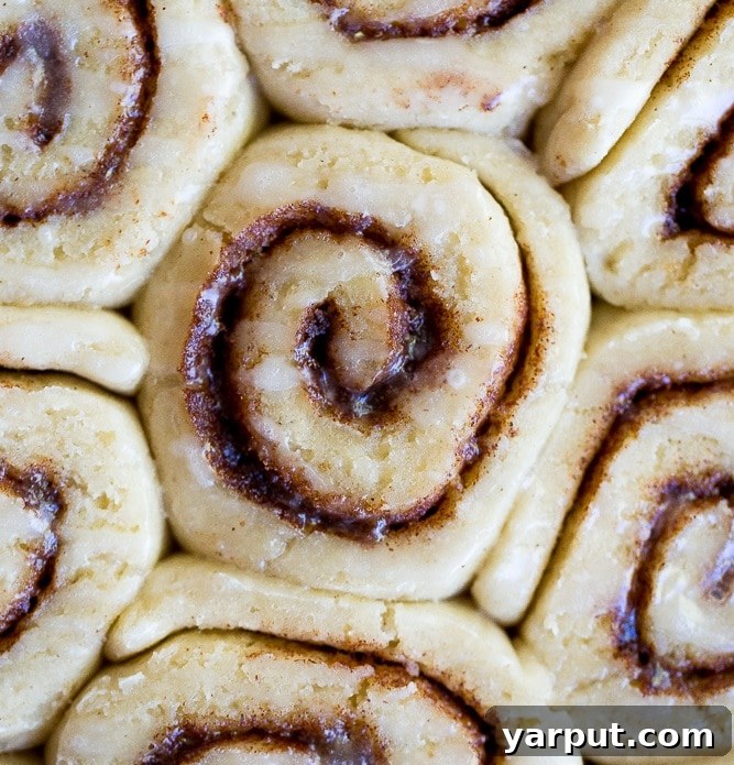 Decadent Vegan Gluten-Free Cinnamon Rolls 5 A close-up shot of the best gluten-free cinnamon rolls, freshly baked and generously drizzled with white glaze.